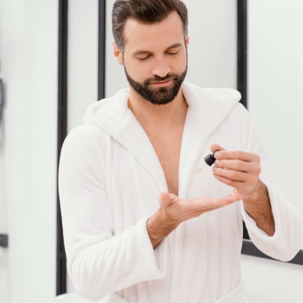 Une collection de produits de soins pour hommes, comprenant de la cire coiffante et des brosses, soigneusement disposés sur une surface en bois pour illustrer une routine de soin quotidienne complète.