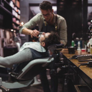Barbier professionnel taillant soigneusement la barbe d'un client dans un salon élégant.